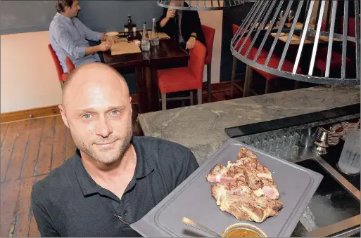  ??  ?? PRIME RIB: Don Armando eatery manager JeanPaul van der Spuy with a portion of prime rib steak, or bife con costilla.