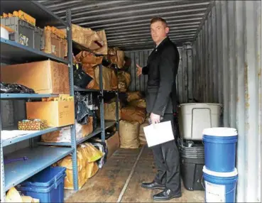  ?? TANIA BARRICKLO — DAILY FREEMAN ?? Detective Lt. Dirk Budd of the Ulster County Sheriff’s Office points to bags filled with more than 300 pounds of marijuana seized from several homes that were being used as grow houses.