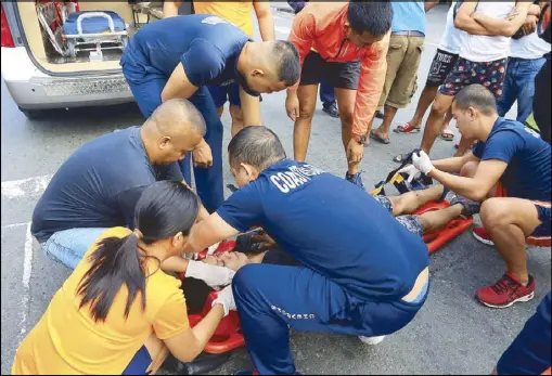  ?? EDD GUMBAN ?? Philippine Coast Guard medical team members administer first aid to a fellow PCG members after he was hit by a cargo truck along Railroad street in Port Area, Manila yesterday. The victim was brought to a nearby hospital for treatment.