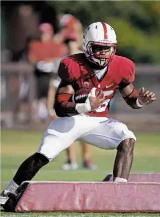  ?? Photos by Michael Macor / The Chronicle ?? Running back Barry Sanders, whose father was inducted into the Pro Football Hall of Fame in 2004, runs through drills as he competes for a starting spot at Stanford.