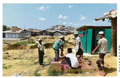  ?? — AFP ?? Cleaning up: Rohingya boys taking their ablutions for afternoon prayers at a refugee camp in Ukhia, Cox’s Bazar.