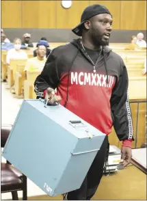  ?? Brodie Johnson • Times-Herald ?? Demetrius Lee delivers the first election box of the evening to the circuit courtroom at the St. Francis County Courthouse Tuesday soon after polls closed at 7:30 p.m.