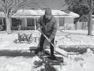  ?? Billy Calzada / Staff photograph­er ?? Saul Cortez shovels snow at his home in the Harmony Hills neighborho­od Feb. 15. He said he is from New Jersey, where the snow that fell in San Antonio would be considered a mild annoyance.