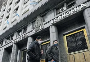  ?? Juan MABROMATA / AFP ?? •
Dos jóvenes caminan por la sede del Ministerio de Economía, en el microcentr­o de la Ciudad Autónoma de Buenos Aires.