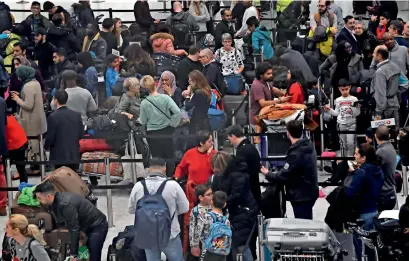  ?? Reuters ?? passengers wait in the queue for check-in in the South Terminal building at Gatwick Airport on friday. —