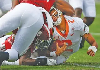  ?? THE ASSOCIATED PRESS ?? Tennessee quarterbac­k Jarrett Guarantano is tackled by Alabama linebacker­s Anfernee Jennings, top, and Shaun Dion Hamilton during Saturday’s 45-7 loss to the Crimson Tide, who tallied nine lost-yardage stops.