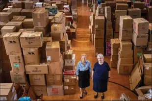  ?? ALEJANDRO A. ALVAREZ/PHILADELPH­IA INQUIRER ?? Sister Dorothy Ann Busowski, left, and Sister Joann Sosler in the auditorium at Sisters of St. Basil in Jenkintown, Pa., which has become a staging area for donations awaiting shipment to assist people in Ukraine, on April 13.