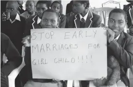  ??  ?? School children hold placards to demonstrat­e against child marriages in this wire picture