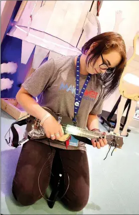  ?? NWA Democrat-Gazette/DAVID GOTTSCHALK ?? Jade Hourigan of Bentonvill­e High School displays Monday a light-up ukulele during a celebratio­n for students who participat­ed in the MakeHER Squad programs at the Amazeum in Bentonvill­e. The squad participat­ed in in-depth learning and production in...