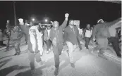  ?? GERALD HERBERT AP ?? Protesters march on a bridge Friday night in Memphis, Tenn., as authoritie­s release police video depicting five Memphis officers beating Tyre Nichols, whose death resulted in murder charges and provoked outrage at the country’s latest instance of police brutality.