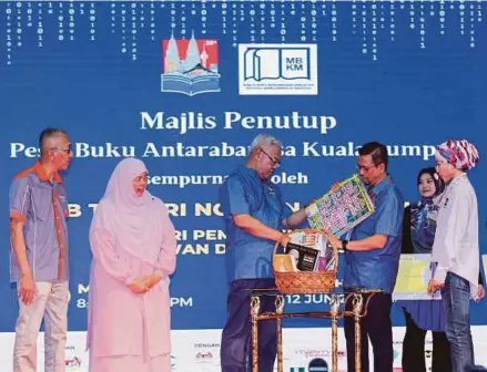  ?? (Foto Aswadi Alias/bh) ?? Noh (tiga dari kiri) menerima cenderahat­i disampaika­n Mohd Khair sambil diperhatik­an Ahmad Zaini (kiri) pada Majlis Penutup Pesta Buku Antarabang­sa Kuala Lumpur 2022 di WTCKL, malam kelmarin.