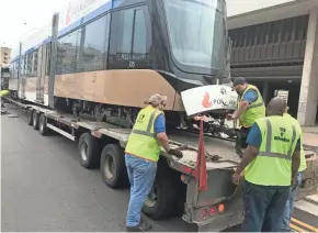  ?? JAMES B. NELSON / MILWAUKEE JOURNAL SENTINEL ?? Workers on Friday prepare to unload the last of five streetcars delivered in downtown Milwaukee. Known as The Hop, the city's new streetcar system will begin operation in late fall.