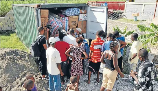  ??  ?? Good things arrive: One of three containers full of donated goods sent from New Zealand is opened in Haiti.