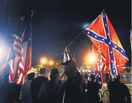  ?? Pictures / AP ?? Protesters fly Confederat­e flags as the statue is removed.