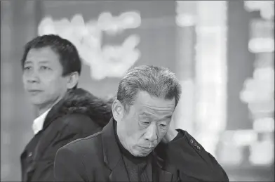  ?? LU QIJIAN / FOR CHINA DAILY ?? Two men watch the stock market at a broker’s office in Fuyang, Anhui province on Friday. The IPO reform plan, which was released on Nov 30, was widely welcomed by the market.