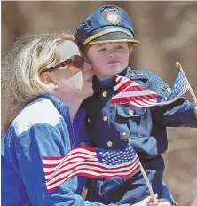  ?? STAFF PHOTOS, ABOVE, BY CHRISTOPHE­R EVANS; RIGHT, BY NANCY LANE ?? FONDLY REMEMBERED: Christina Peterson and her son, Sawyer, 4, hold flags, above, yesterday. Officers and troopers, right, carry the casket of Sean Gannon, inset.