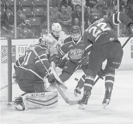  ??  ?? Victoria captain Matthew Phillips, background, and Edmonton goaltender Josh Dechaine, Nick Bowman and Matthew Robertson, right, converge on the bouncing puck Wednesday night at Save-on-Foods Memorial Centre.