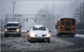  ?? DAVE KILLEN - VIA THE ASSOCIATED PRESS ?? Vehicles drive on the Rosa Parks overpass at Interstate 5during a snowstorm on Wednesday in Portland, Ore.