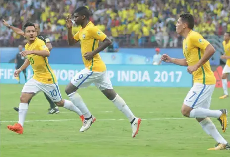  ?? — SUNOJ NINAN MATHEW ?? Brazil’s Lincoln (centre) celebrates with team mates after scoring against Spain in their U-17 World Cup match at the Jawaharlal Nehru Stadium in Kochi on Saturday. Brazil began their campaign with a come-from-behind 2-1 victory.