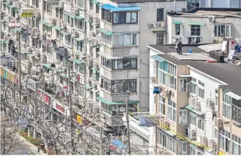  ?? — AFP photo ?? Residents stand on the rooftop of a building during the second stage of a Covid-19 lockdown in the Jing’an district in Shanghai.