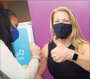  ??  ?? Fairfield First Selectwoma­n Brenda Kupchick gives a thumbs up as she receives a COVID-19 vaccinatio­n from Jaime Vargas at Hartford HealthCare’s new mass vaccinatio­n clinic on the West Campus of Sacred Heart University in Fairfield.