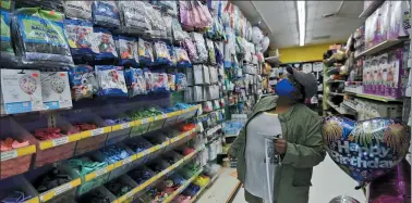  ?? TONY DEJAK— THE ASSOCIATED PRESS ?? Melba Harris-Coles looks for merchandis­e at the Party Place, May 12, in Mayfield Heights. Ohio retail businesses were set to reopen Tuesday following a nearly two-month-long shutdown ordered by Gov. Mike DeWine to limit the spread