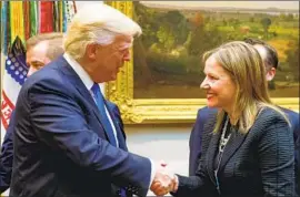  ?? Saul Loeb AFP/Getty Images ?? GENERAL MOTORS CEO Mary Barra, shown with President Trump at the White House in 2017, says trade issues are among the “headwinds” the firm faces.