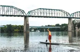  ??  ?? Ben Friberg paddles toward the Market Street Bridge on Thursday.