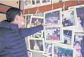  ??  ?? ABOVE Kazuo Ouchi, 62, the father of baseball player Ryoma Ouchi, points to a family photograph on a wall of their now-abandoned house after their evacuation caused by the 2011 disaster in Iitate.