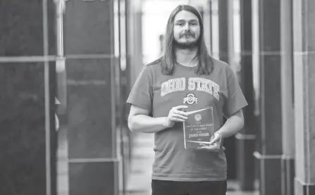  ?? JOSHUA A. BICKEL/COLUMBUS DISPATCH ?? James Nesser poses outside the Franklin County courthouse auditorium with the Julie Fisher-padgett Award that he received during his graduation from LINC, the Franklin County Municipal Court’s mental-health program, on Wednesday.