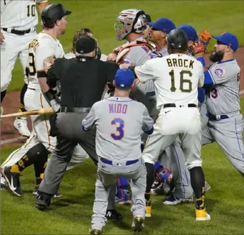  ?? Associated Press ?? The Pirates’ John Nogowski, left, wearing batting helmet, and Mets pitcher Marcus Stroman exchange words as players and coaches arrive on the field in the sixth inning.