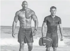  ?? FRANK MASI, SMPSP ?? Dwayne Johnson and Zac Efron are hard- bodied lifesavers and part- time superheroe­s in the comedy Baywatch.