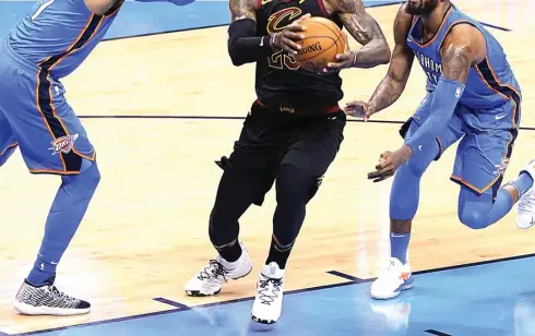  ?? FOTO-FOTO: ROCKY PADILA/JAWA POS ?? SEKARANG BAHAGIA: Superstar Cleveland Cavaliers LeBron James dihadang dua bintang Oklahoma City Thunder yakni Carmelo Anthony (kiri) dan Paul George di Chesapeake Energy Arena, Oklahoma City, kemarin. Cavaliers menang 120-112.