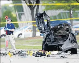  ?? BrandonWad­e Associated Press ?? AN FBI INVESTIGAT­OR examines the scene where twomen suspected of planning to attack an anti-Islam event were fatally shot by police in Garland, Texas.
