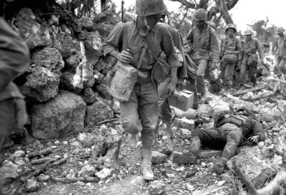  ??  ?? US marines pass a dead Japanese soldier in a village in the prefecture of Okinawa in 1945