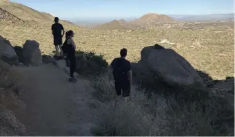  ??  ?? EXPANSIVE VIEW: Hikers along Tom’s Thumb Trail in Scottsdale, Ariz., stop to take in the view.