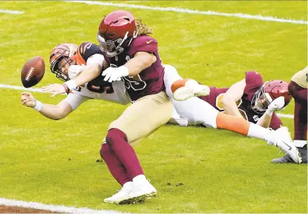  ?? AL DRAGO/ASSOCIATED PRESS ?? Washington defensive end Chase Young stops Cincinnati Bengals quarterbac­k Joe Burrow short of the goal line, knocking the ball loose in Sunday’s game. Young has 25 tackles and 3.5 sacks in nine games this season.