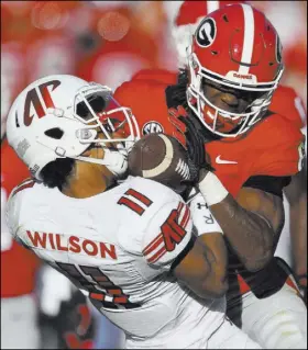  ?? Mike Stewart The Associated Press ?? Georgia running back James Cook hits Austin Peay wide receiver DeAngelo Wilson on a second-half kick return Saturday in the Bulldogs’ 45-0 win.