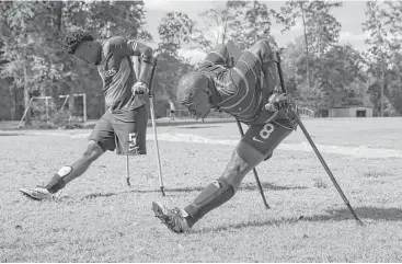  ?? Leslie Plaza Johnson ?? Members of the Haitian National Amputee Soccer Team warm up before an exhibition match at Lents Family Park. During games, players are not allowed to wear prosthetic­s or to touch the ball with their crutches.