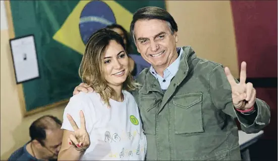  ?? RICARDO MORAES / AP ?? Jair Bolsonaro, y su mujer, Michelle, saludando el pasado domingo tras votar en un colegio electoral de Río de Janeiro