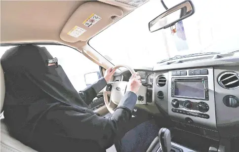  ??  ?? A Saudi woman, Amira, who works in Aramco, drives to work in Dammam, Saudi Arabia. — Reuters photo