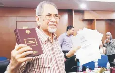  ??  ?? Wan Junaidi holds up a copy of the Federal Constituti­on.