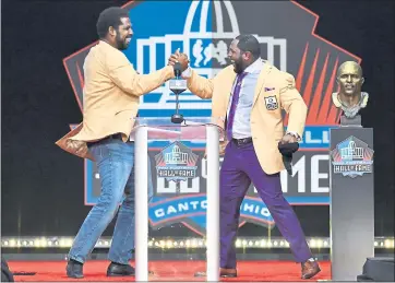  ?? DAVID RICHARD — THE ASSOCIATED PRESS ?? Former Baltimore Ravens teammates Ray Lewis, right, and Jonathan Ogden shake hands during Lewis’ induction speech.