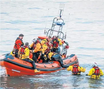  ??  ?? Members of the volunteer Kinghorn RNLI lifeboat crew practise winching casualties from the Firth of Forth.