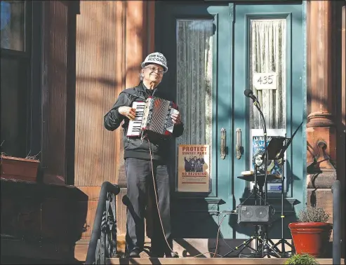  ?? (AP/Kathy Willens) ?? Musician Paul Stein, who has played the accordion since he was 8 years old, entertains neighbors April 15 with an “Emergency Accordion Stoop Extravagan­za” concert from the top step of his stoop in the Sunset Park neighborho­od of Brooklyn in New York. “Music ... lifts people’s spirits and brings them together,” Stein says. “We need to keep our spirits up. We need hope now. That’s what we need to get through this difficult period.”