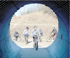  ?? Keith Bryant/The Weekly Vista ?? Kira Workman (foreground) heads into a trail tunnel under Chelsea Road on the freshly-opened section of Little Sugar Creek trails, followed by Trey Staley (left, background), Mike Workman, Justin Staley and Jason Fischgrabe.