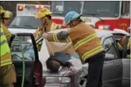  ?? MARIAN DENNIS — DIGITAL FIRST MEDIA ?? First responders from Ridge Fire Company taking part in a mock crash at Owen J. Roberts High School Thursday place a sheet over one of the “deceased” students.