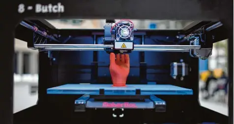  ?? Foto: Christian Platz, dpa ?? Fasziniere­nd: Ein 3D Drucker druckt ein rotes Hand Modell.
