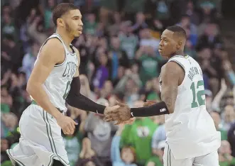  ?? STAFF PHOTOS BY CHRISTOPHE­R EVANS ?? ONE DOWN, 15 TO GO: Terry Rozier (right) celebrates with Jayson Tatum, and Jaylen Brown (below) throws down a dunk during the Celtics’ 113-107 overtime win against the Milwaukee Bucks in Game 1 of the playoffs yesterday at the Garden.