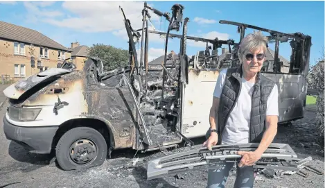  ?? Attwood. Picture: Stewart ?? Mary Parry with the burnt-out minibus in Methil used to take special needs children to school.